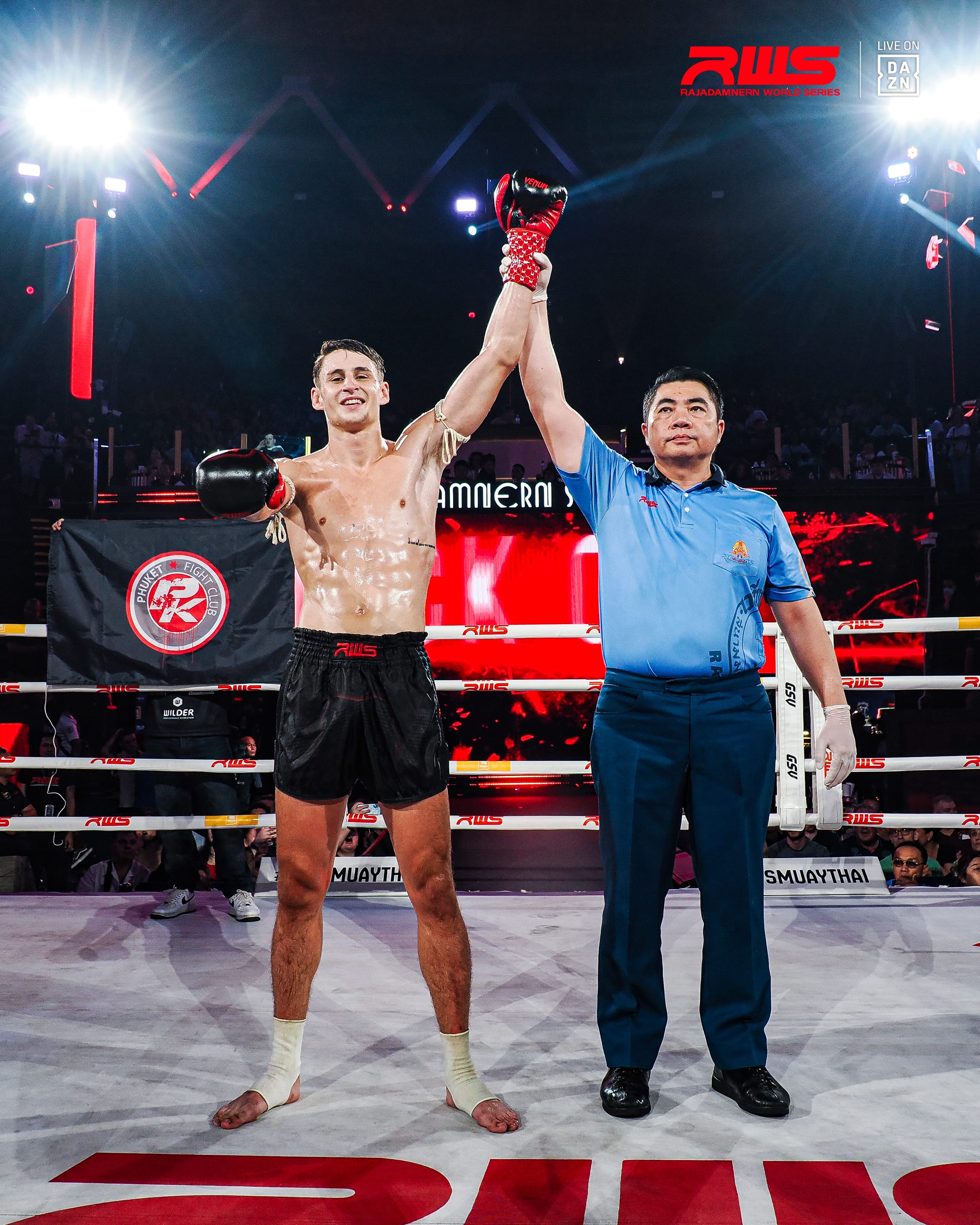 The referee raises Louie Doherty arm in victory inside the ring