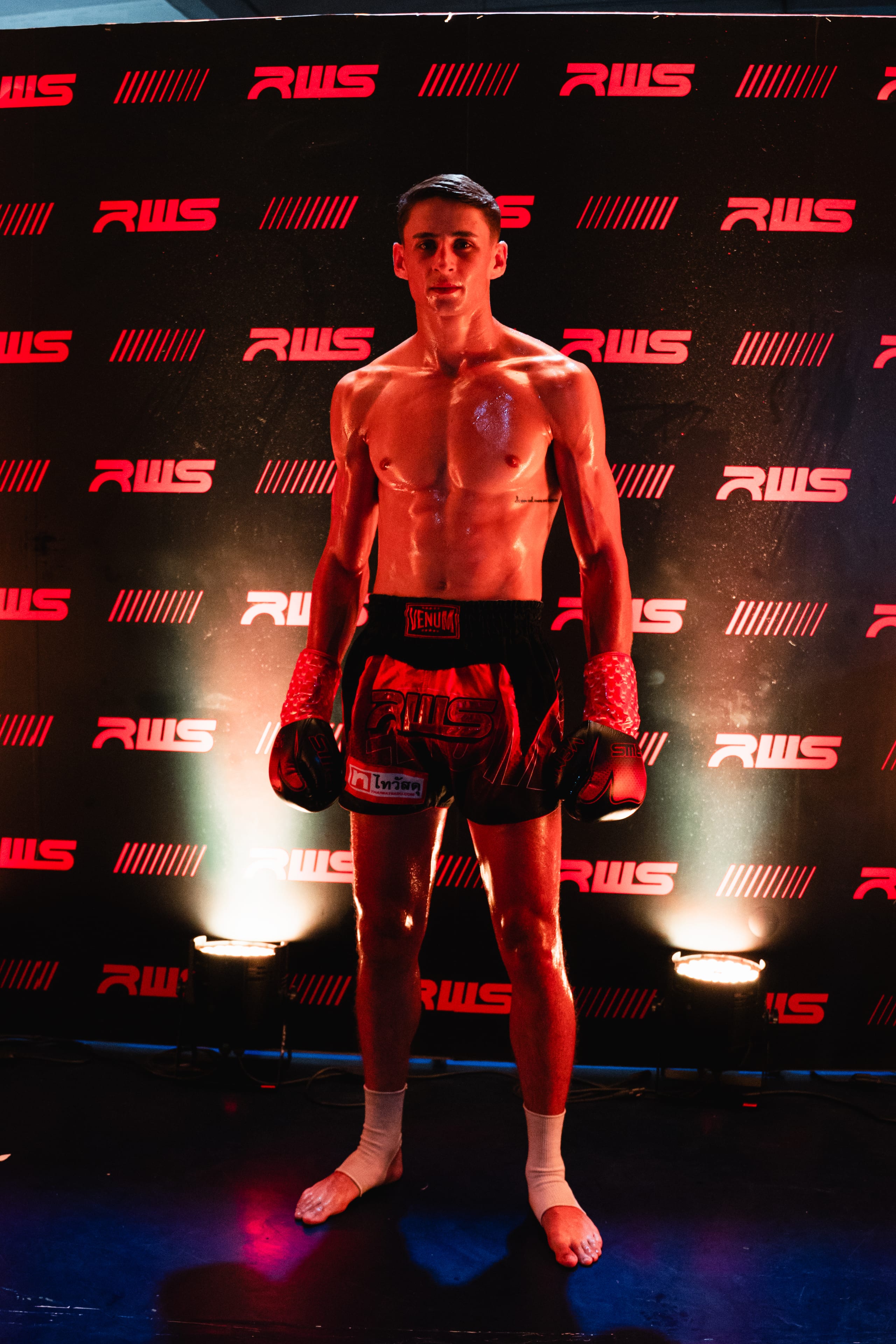 Louie Doherty standing in fight stance against a red-lit Rajadamnern World Series backdrop